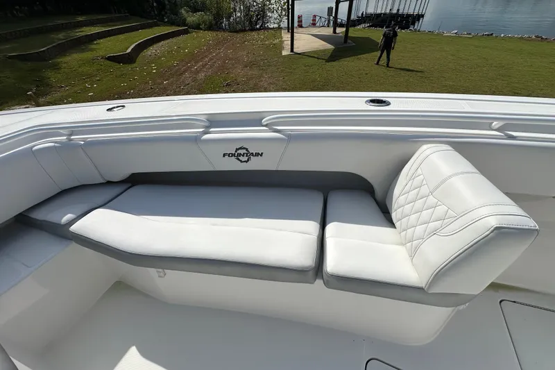 Slide: The Image of 2022 Fountain 38 CC LS boat with white cushioned seating, dockside view. - 15