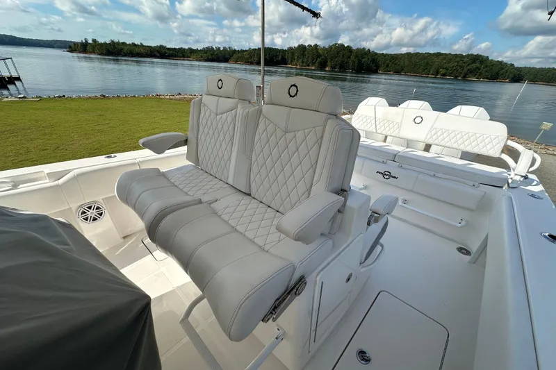 Slide: The Image of 2022 Fountain 38 CC LS boat interior with luxurious seating, overlooking a serene lake. - 17