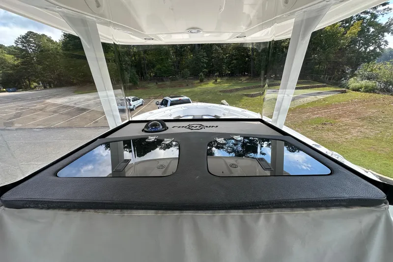 Slide: The Image of 2022 Fountain 38 CC LS boat interior with windshield view of parking lot and trees. - 38