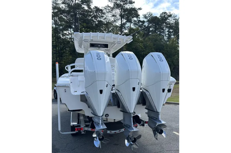 Slide: The Image of 2022 Fountain 38 CC LS boat with triple outboard engines, parked outdoors. - 4