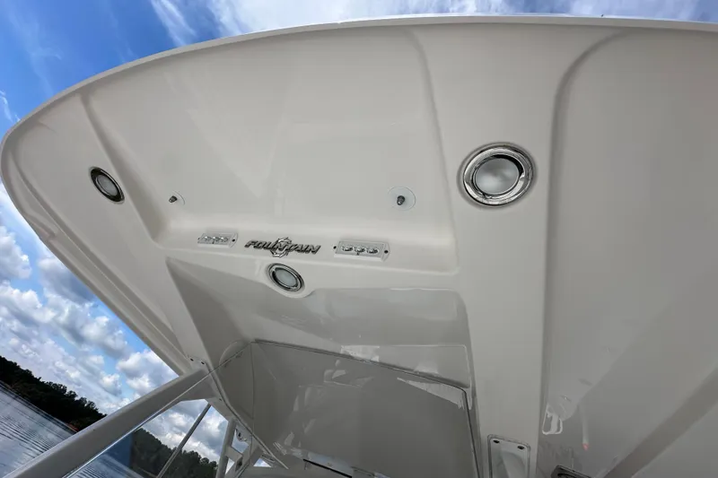 Slide: The Image of 2022 Fountain 38 CC LS boat canopy with integrated lights and logo, under a blue sky. - 51