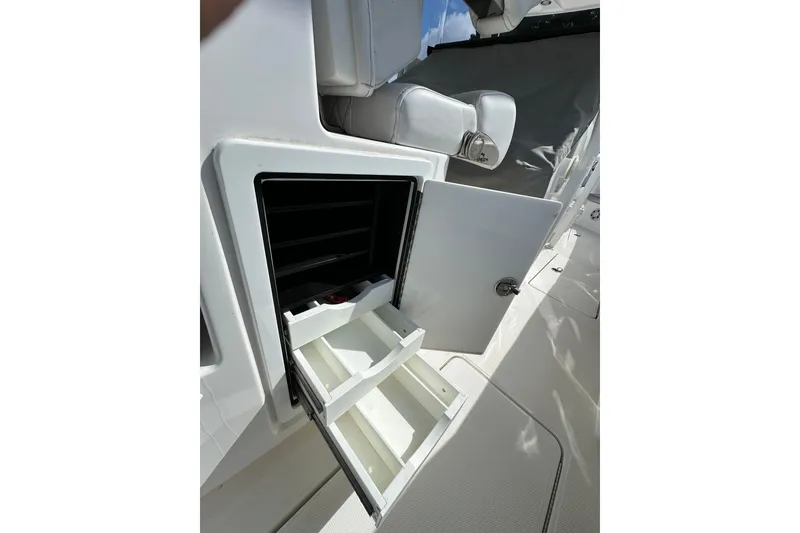 Slide: The Image of Open storage compartment on 2022 Fountain 38 CC LS boat, featuring organized interior shelves. - 54