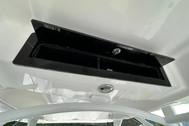 Slide: The Image of 2022 Fountain 38 CC LS boat storage compartment with sleek black finish. - 58