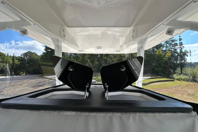 Slide: The Image of 2022 Fountain 38 CC LS boat interior with open storage compartments, surrounded by trees. - 59