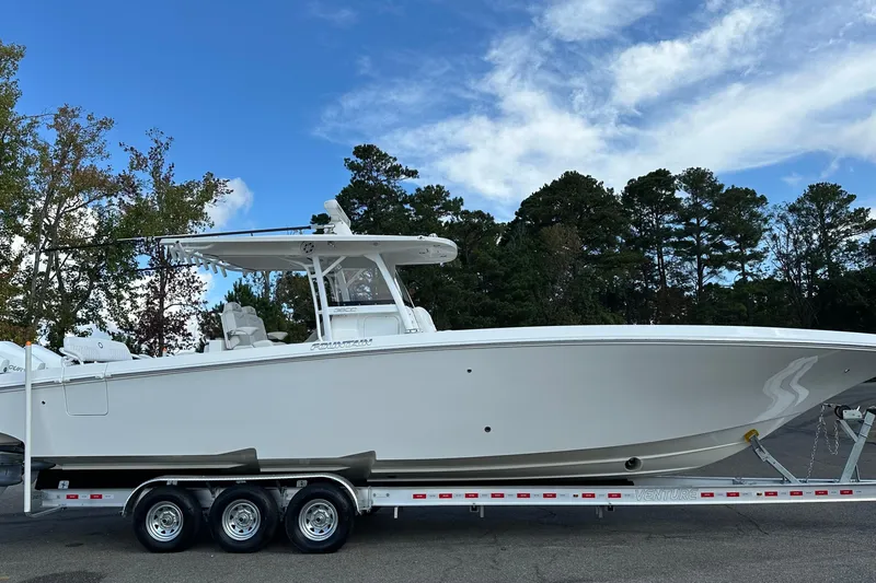 Slide: The Image of 2022 Fountain 38 CC LS boat on trailer, parked outdoors under blue sky. - 6