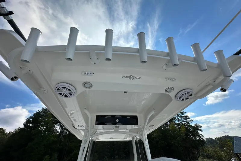 Slide: The Image of 2022 Fountain 38 CC LS boat roof with rod holders and speakers under blue sky. - 60