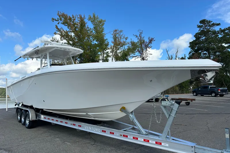 Slide: The Image of 2022 Fountain 38 CC LS boat on trailer, parked outdoors under blue sky. - 9