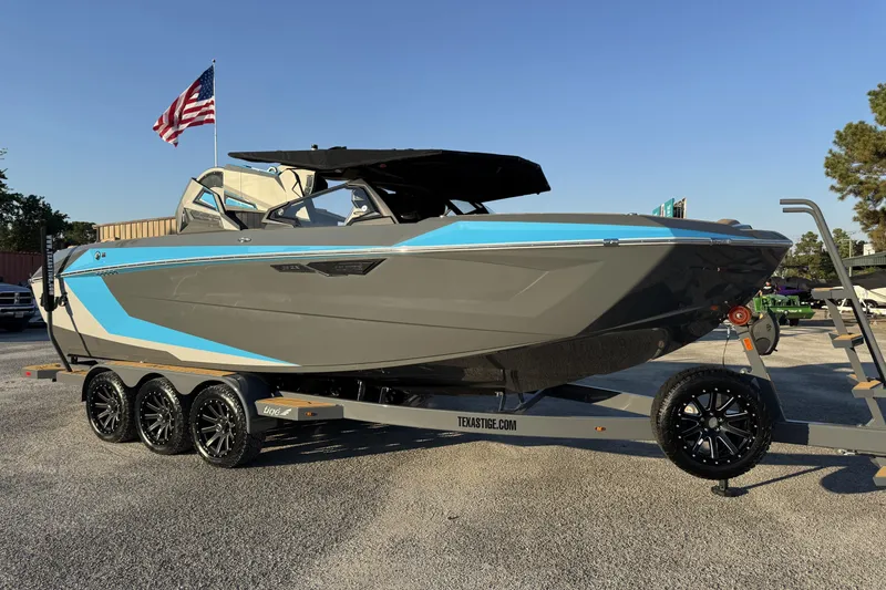 Slide: The Image of 2026 Tigé Ultré 25ZX boat on trailer with American flag in background. - 22