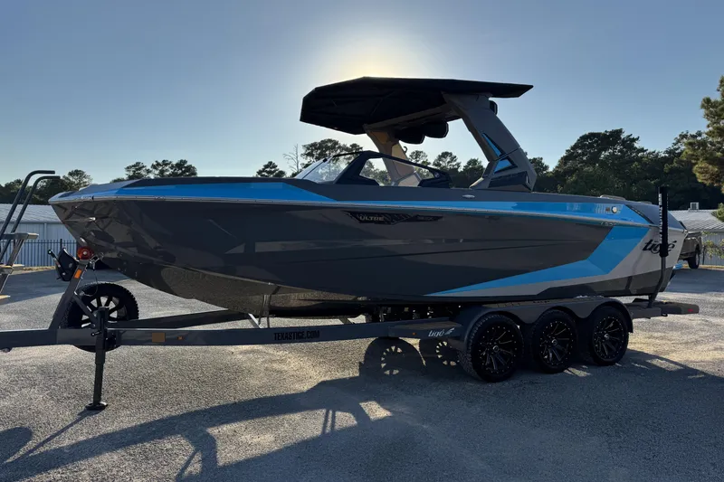 Slide: The Image of 2026 Tigé Ultré 25ZX boat on trailer, sleek design, blue and gray color scheme. - 5