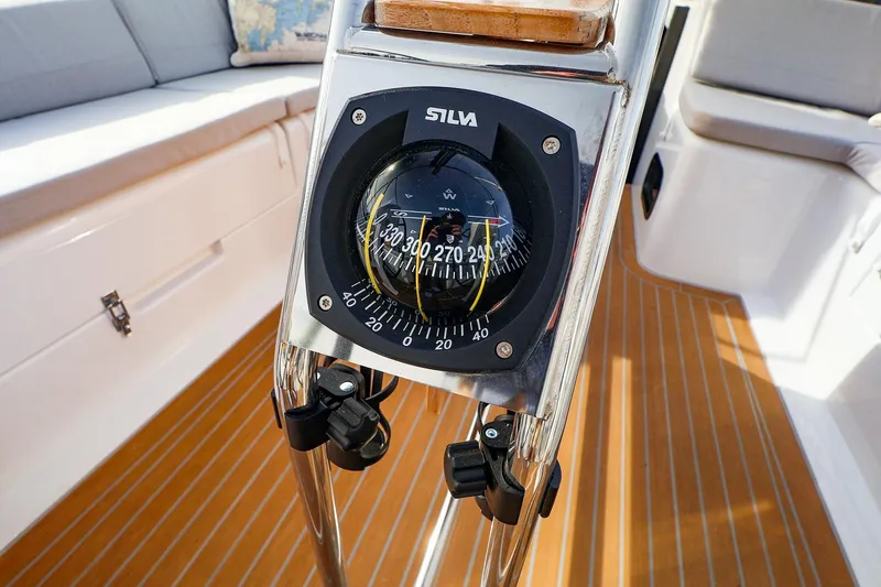 Slide: The Image of Compass on 2025 Hanse 458 yacht, featuring teak deck and cushioned seating. - 15