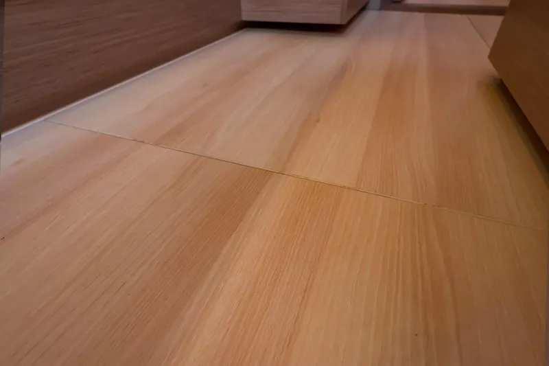 Slide: The Image of Wooden flooring inside 2025 Hanse 458 yacht, showcasing sleek and modern design. - 33