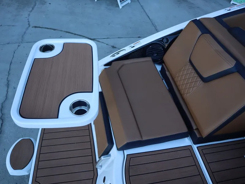 Slide: The Image of 2026 Yamaha Boats 252SD interior with brown seating and table, featuring cup holders. - 7