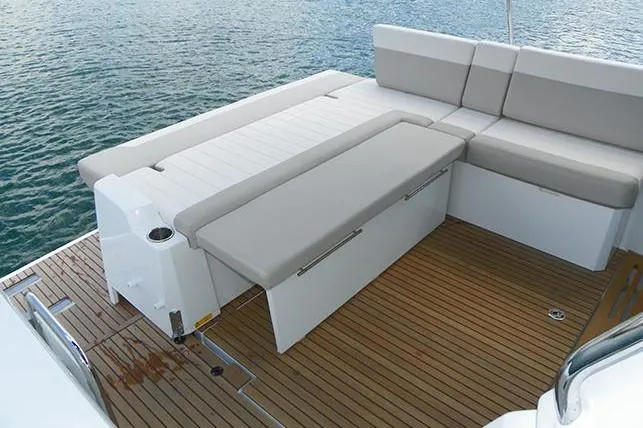 Slide: The Image of 2019 Jeanneau Leader 33 yacht interior with seating and wooden table in a marina setting. - 8