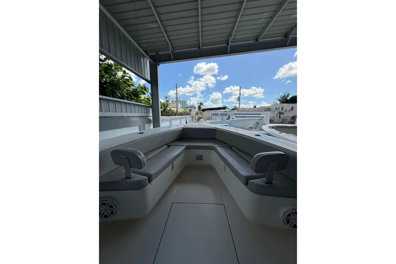 Slide: The Image of 2019 Contender 35 ST boat interior with seating, under a metal roof, blue sky visible. - 22