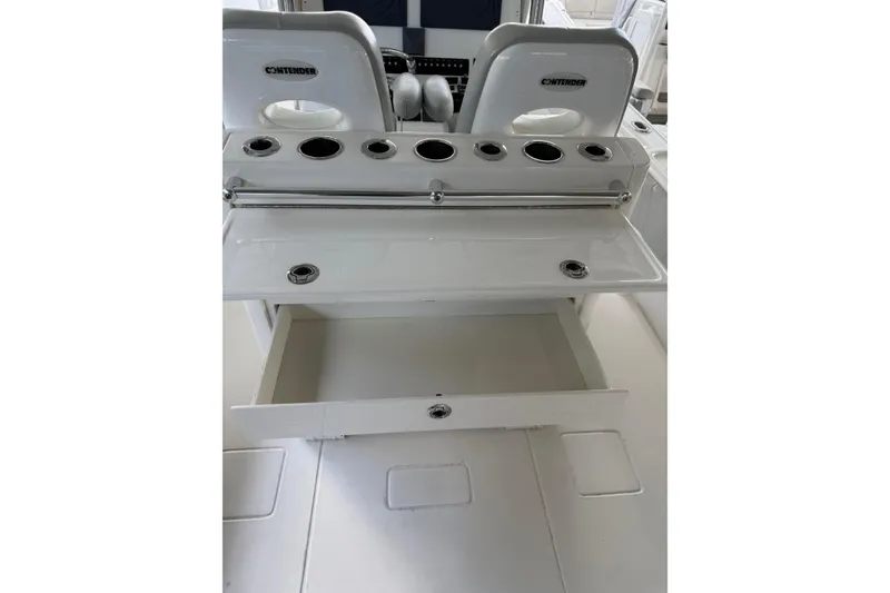 Slide: The Image of 2019 Contender 35 ST boat interior with open storage drawer and rod holders. - 30