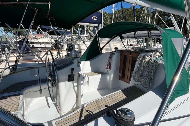 Slide: The Image of 2004 Beneteau 331 sailboat cockpit with green canopy and wooden accents. - 14