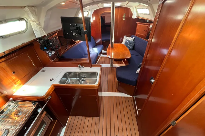 Slide: The Image of Interior of 2004 Beneteau 331 sailboat with wood finish, kitchen, and seating area. - 15