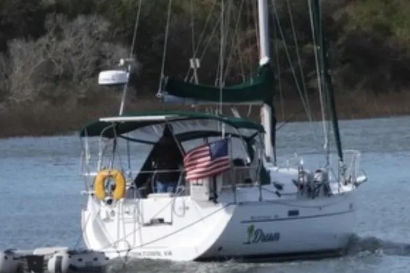 Slide: The Image of 2004 Beneteau 331 sailboat with American flag on calm water. - 2