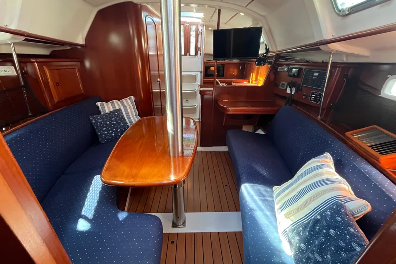 Slide: The Image of 2004 Beneteau 331 yacht interior with cozy seating, wooden table, and modern amenities. - 24