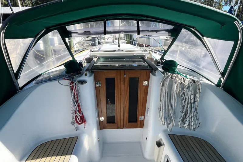 Slide: The Image of 2004 Beneteau 331 sailboat cockpit with green canopy and wooden doors. - 7