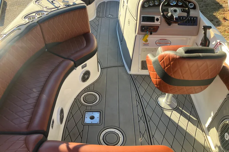 Slide: The Image of 2000 Chaparral Sunesta 232 boat interior with brown leather seating and modern dashboard. - 10