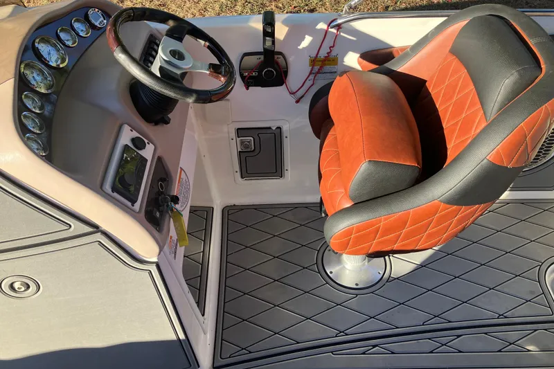 Slide: The Image of 2000 Chaparral Sunesta 232 boat interior with steering wheel and red-black seat. - 12