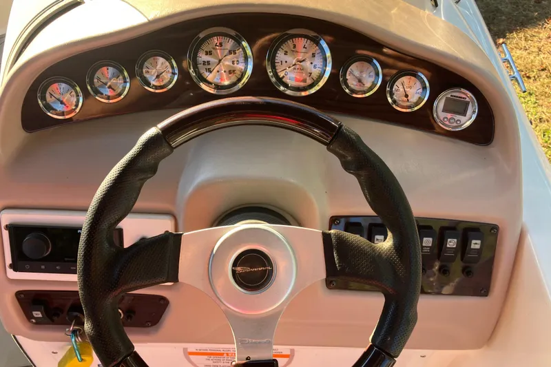 Slide: The Image of Steering wheel and dashboard of 2000 Chaparral Sunesta 232 boat with gauges. - 14