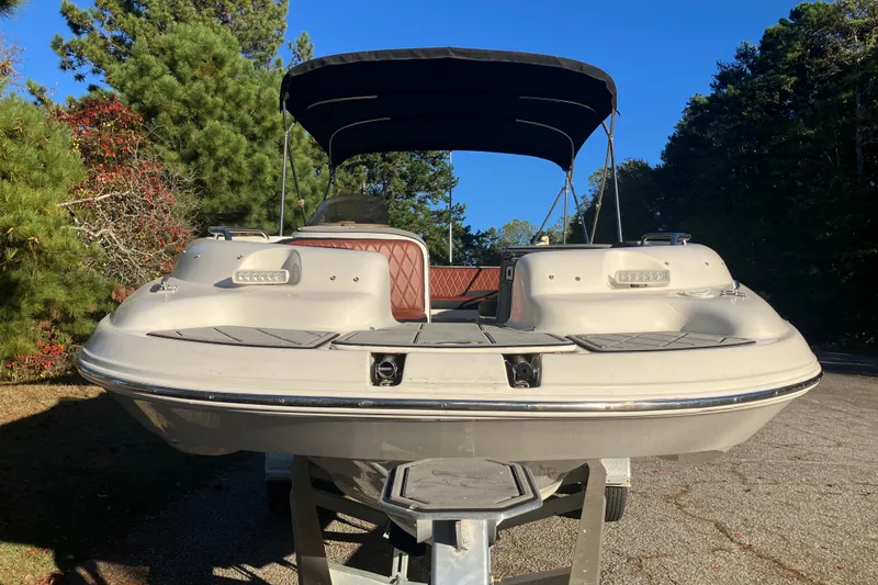 Slide: The Image of 2000 Chaparral Sunesta 232 boat on trailer, surrounded by trees under clear blue sky. - 2