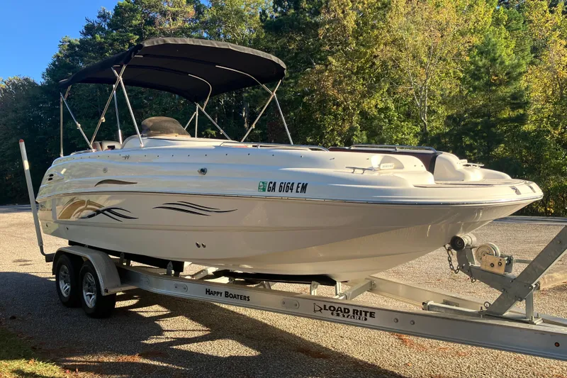 Slide: The Image of 2000 Chaparral Sunesta 232 boat on trailer, parked outdoors with trees in background. - 3