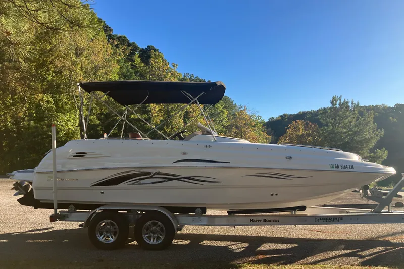 Slide: The Image of 2000 Chaparral Sunesta 232 boat on trailer, parked outdoors with trees in background. - 4