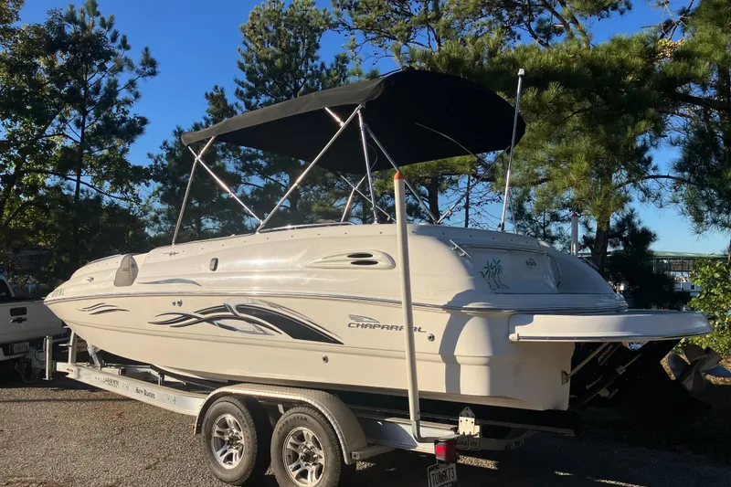 Slide: The Image of 2000 Chaparral Sunesta 232 boat on trailer with canopy, surrounded by trees. - 6