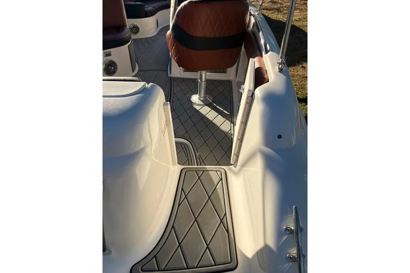 Slide: The Image of 2000 Chaparral Sunesta 232 boat interior with cushioned seating and non-slip flooring. - 8