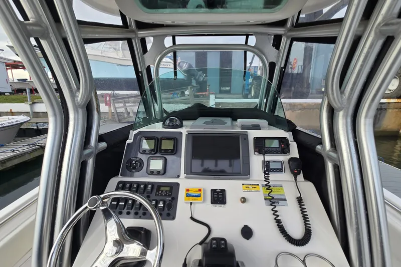 Slide: The Image of 2014 Robalo R240 Center Console boat dashboard with steering wheel and navigation equipment. - 1