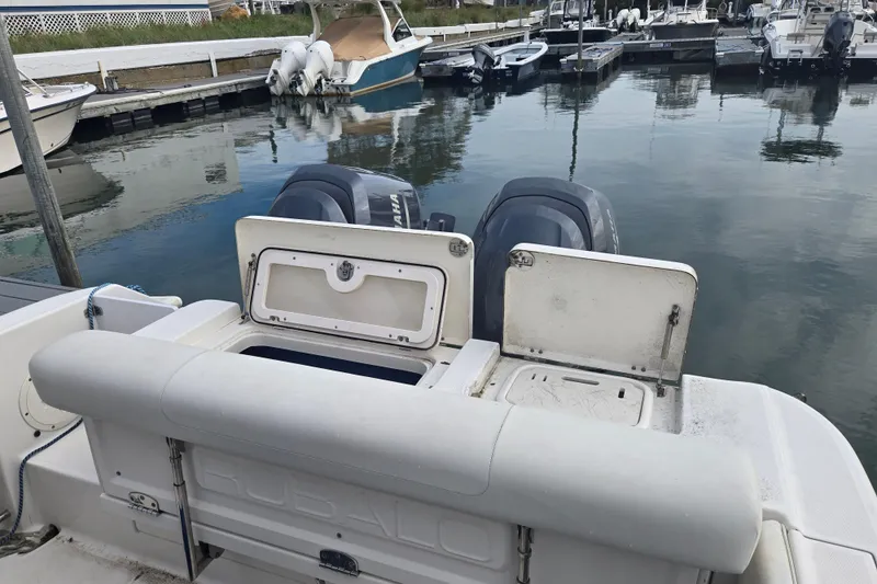 Slide: The Image of 2014 Robalo R240 Center Console boat with dual engines at a marina dock. - 10