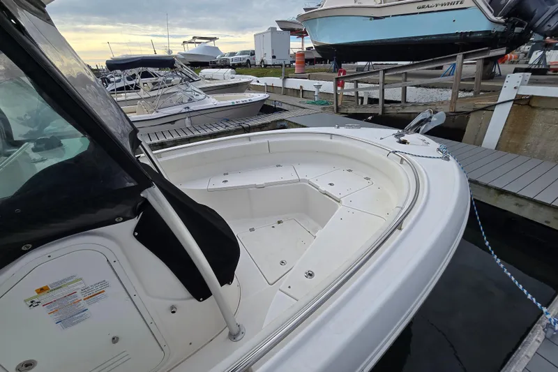 Slide: The Image of 2014 Robalo R240 Center Console boat docked at marina, featuring spacious seating area. - 4