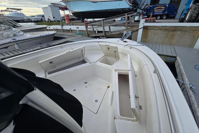 Slide: The Image of 2014 Robalo R240 Center Console boat with open storage compartments at a marina. - 5