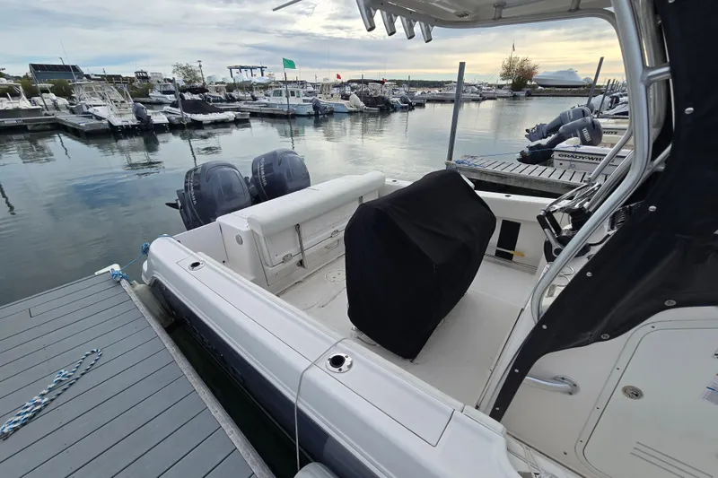 Slide: The Image of 2014 Robalo R240 Center Console boat docked at marina with twin engines. - 7