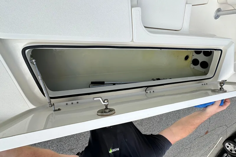 Slide: The Image of 2013 Skeeter SX240 boat storage compartment with open hatch and hydraulic support. - 16
