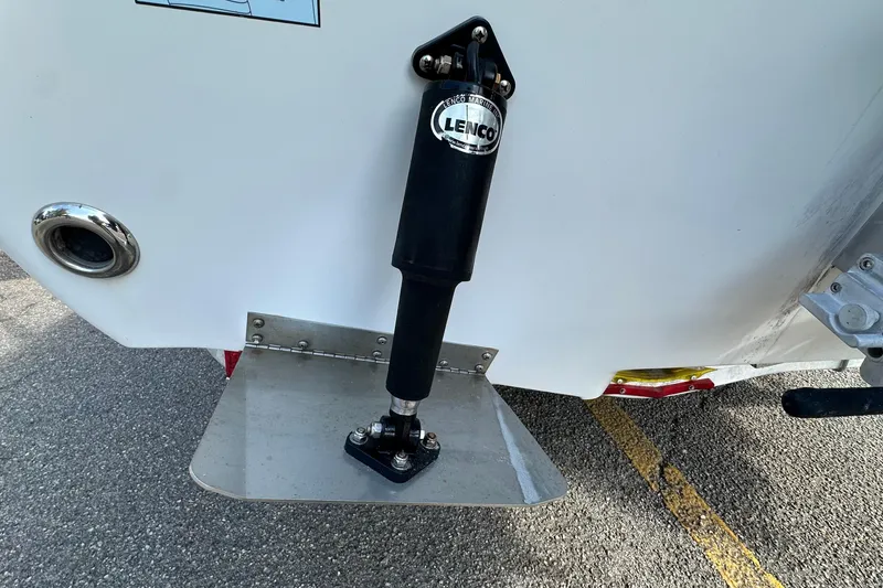 Slide: The Image of 2013 Skeeter SX240 boat trim tab with Lenco actuator on asphalt surface. - 20