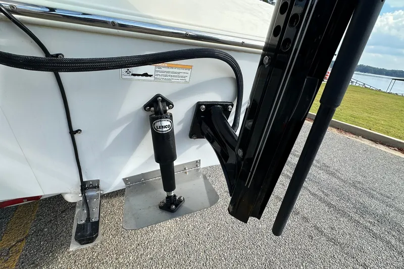 Slide: The Image of 2013 Skeeter SX240 boat with Lenco trim tab system, docked near a lake. - 22