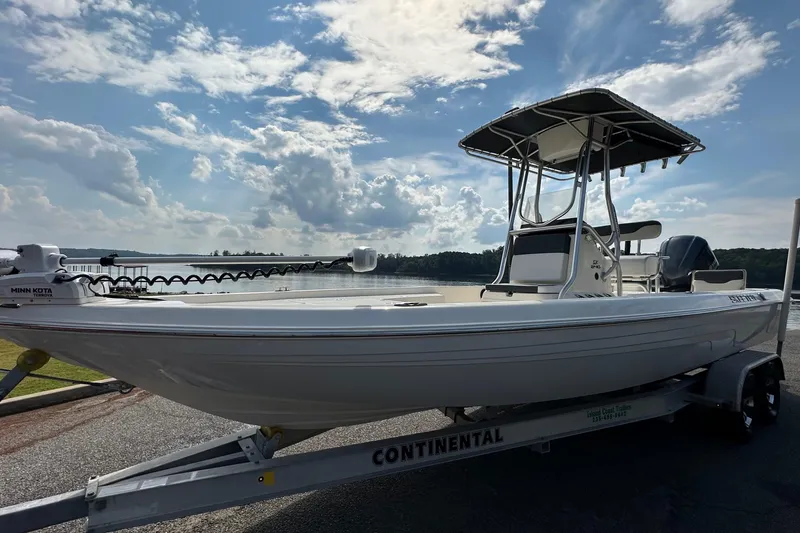 Slide: The Image of 2013 Skeeter SX240 boat on trailer by a lake under a cloudy sky. - 5