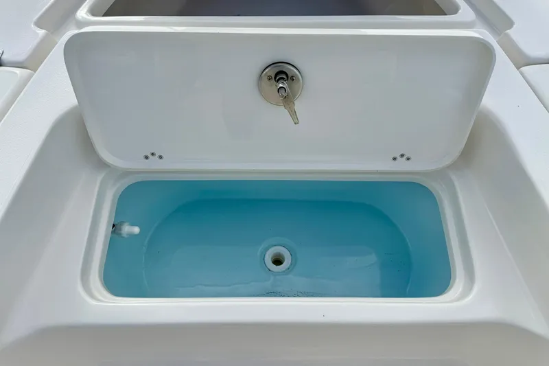 Slide: The Image of 2026 Key West 210 Bay Reef livewell with blue interior and lid open. - 22
