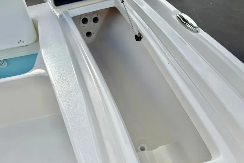 Slide: The Image of 2026 Key West 210 Bay Reef boat storage compartment, white interior, open lid. - 23