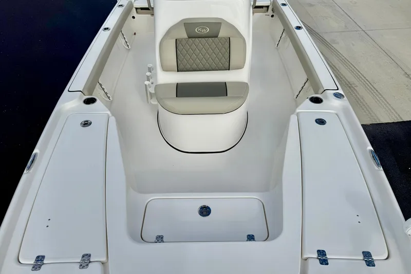 Slide: The Image of 2026 Key West 210 Bay Reef boat interior with cushioned seating and storage compartments. - 26
