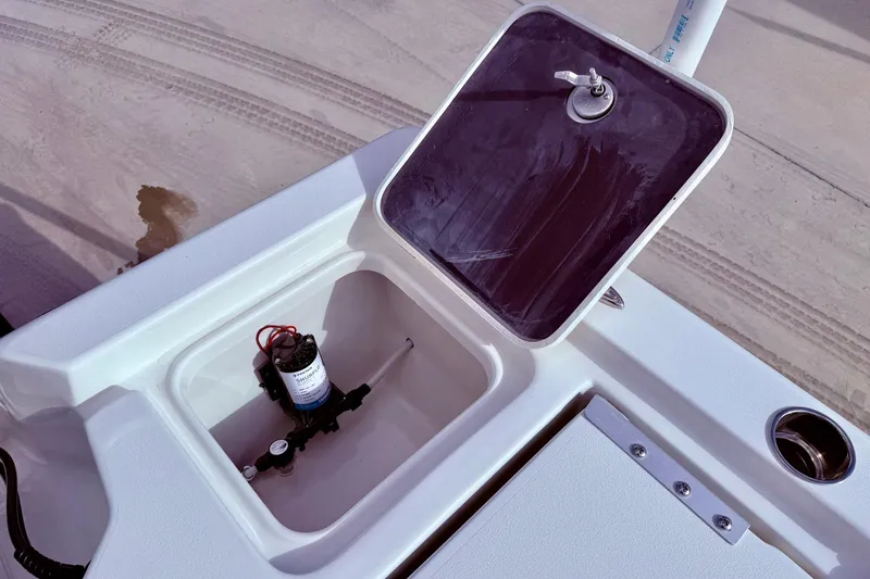 Slide: The Image of 2026 Key West 210 Bay Reef boat compartment with pump and open hatch. - 48