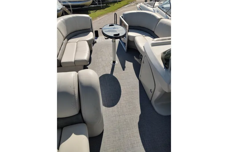 Slide: The Image of Captain's seat and helm of a 2016 Starcraft CX 23 FD boat, featuring steering wheel and controls. - 2