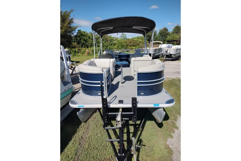 Slide: The Image of 2016 Starcraft CX 23 FD boat interior with open storage, steering console, and seating area. - 8