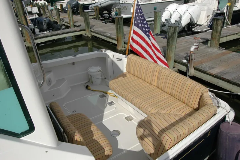 Slide: The Image of 2014 Back Cove 34 boat with striped seating and American flag at dock. - 19