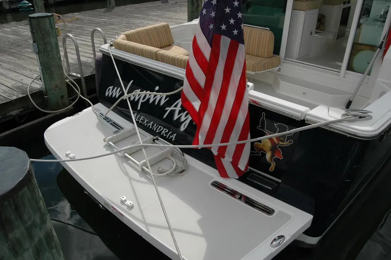 Slide: The Image of 2014 Back Cove 34 boat docked with American flag and striped seating. - 26