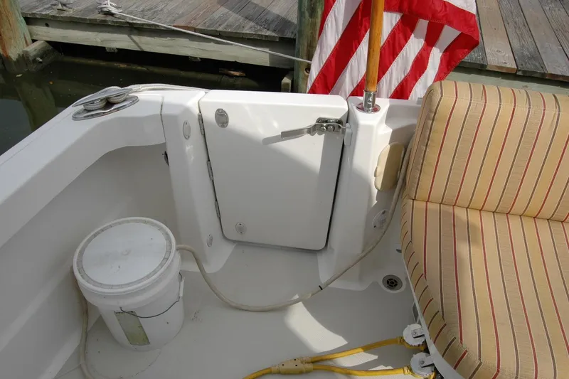 Slide: The Image of 2014 Back Cove 34 boat interior with striped seating, American flag, and dock view. - 33
